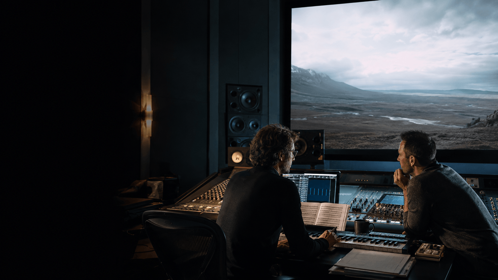 Composer and picture director shaping an original score in a film mixing suite